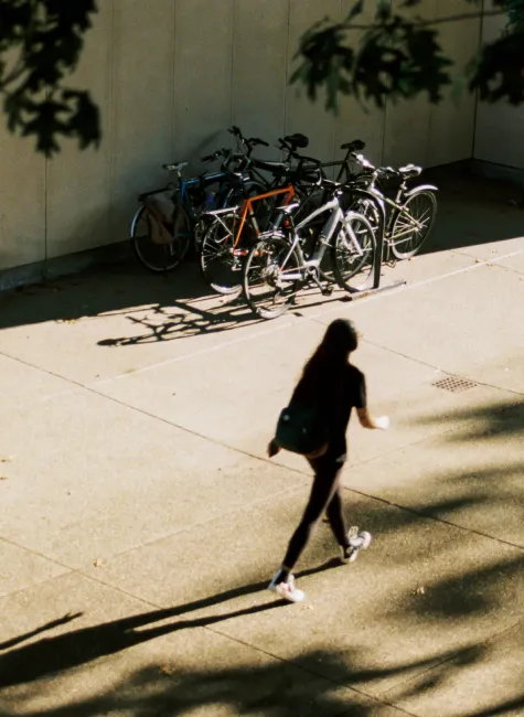 Biciclette parcheggiate e persona che cammina